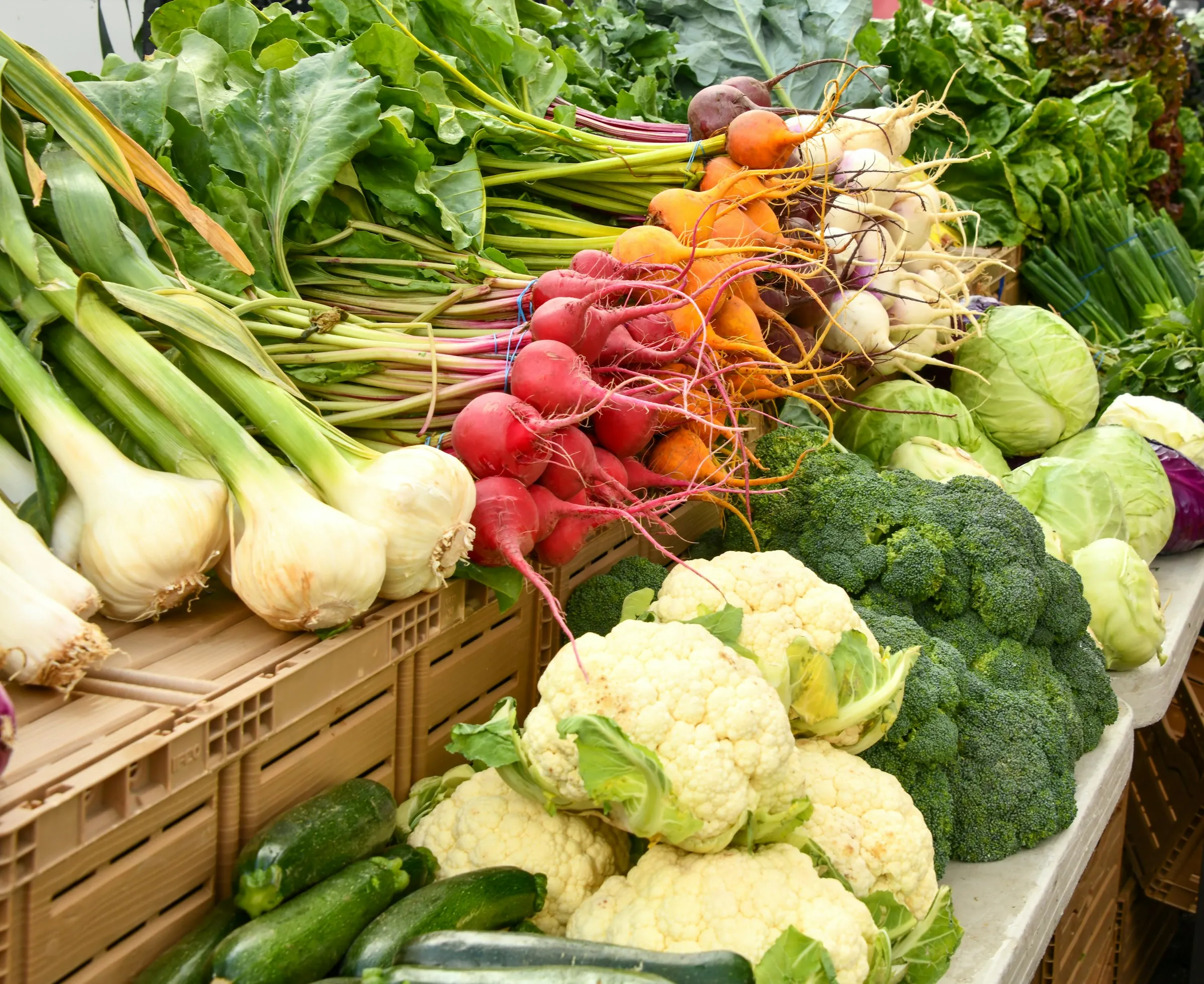 Cipollotti, ravanelli, carote, cavolfiori, broccoli e cavoli su un banco di vendita all'aperto